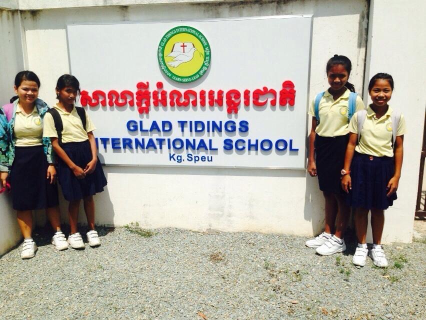 Pupils standing beside the Glad Tidings International School sign